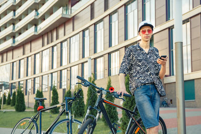 Full length of man standing on bicycle in city