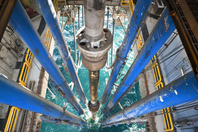 High angle view of drilling riser and pipes in sea at oil rig