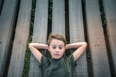 Boy sleeping on wooden planks