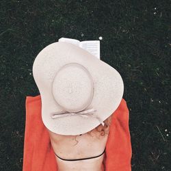 Rear view of woman reading book while lying on beach