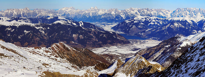 Wide angle aerial panorama of sunny austrian alps in winter near zell am see lake