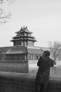 Rear view of a man with built structure against clear sky