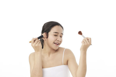 Young woman smiling against white background