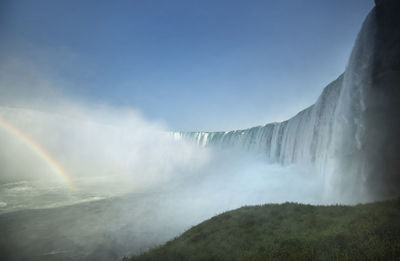 Scenic view of waterfall against sky