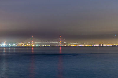 Suspension bridge over river at night