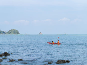 People on sea against sky