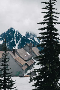 Houses and mountains against sky during winter