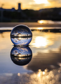 Close-up of illuminated crystal ball against sky during sunset