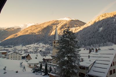 Houses on snow covered mountains against sky