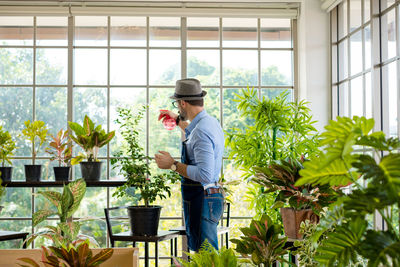 Portrait of smiling man standing in greenhouse