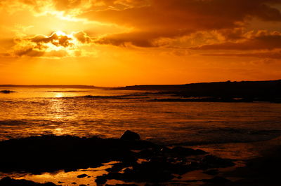 Scenic view of sea against orange sky
