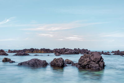 Rocks in sea against sky