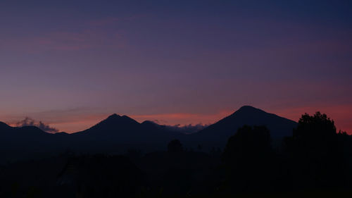 Scenic view of silhouette mountains against romantic sky