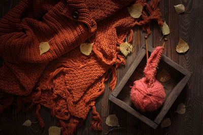 Cozy autumn background with knitted sweater scarf and ball with knitting wood needles