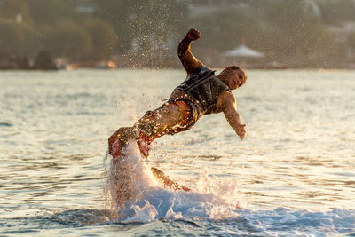 Man flyboarding in sea