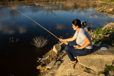 Full length of woman fishing at lake
