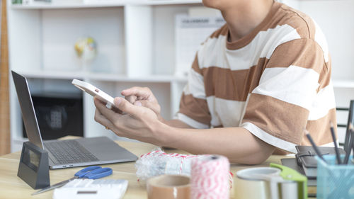 Midsection of woman using mobile phone