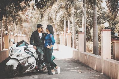 Couple walking on road amidst trees