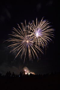 Low angle view of firework display at night