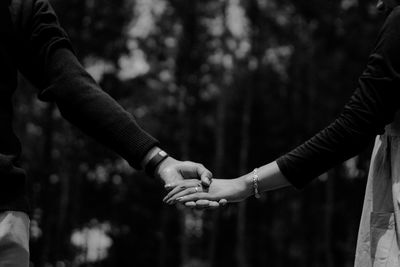 Midsection of couple holding hands