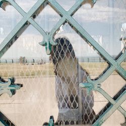 Reflection of fence on glass window