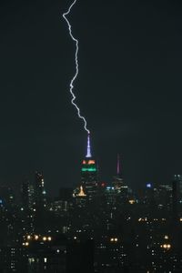 Illuminated cityscape against sky at night