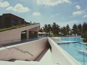 Swimming pool by building against sky