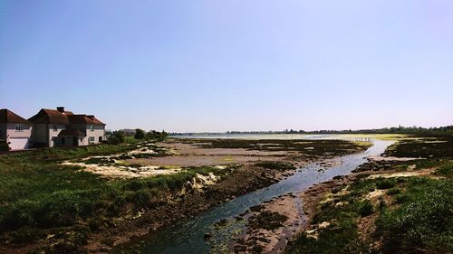 Scenic view of river amidst buildings against clear sky