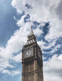 Low angle view of clock tower against cloudy sky