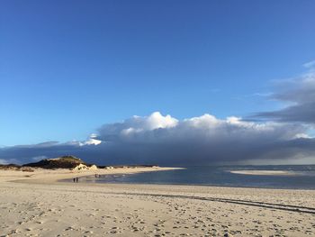 Scenic view of beach against blue sky