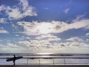Silhouette man on beach against sky
