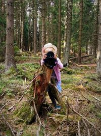 Girl photographing from camera at forest