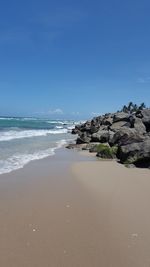 Scenic view of beach against clear blue sky