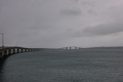 Cloudy monument, very long bridge over the sea