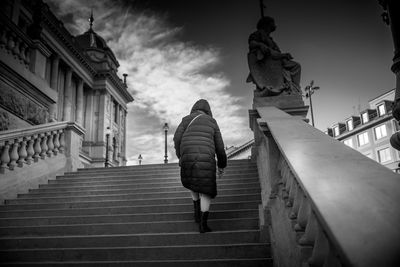 Rear view of woman walking on staircase