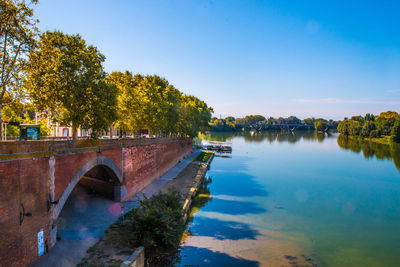 Arch bridge over river against sky