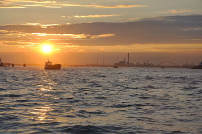 Scenic view of sea against cloudy sky during sunset