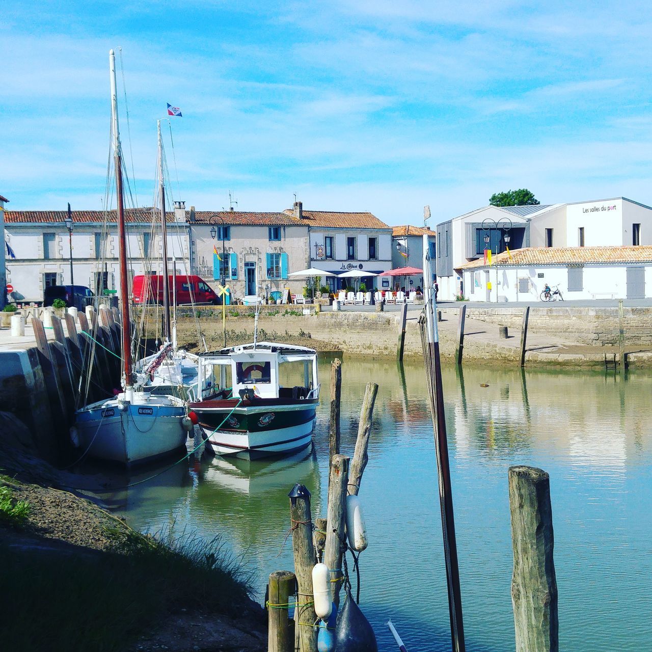 BOATS MOORED IN HARBOR AT DOCK AGAINST SKY