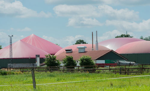 Houses by barn against sky