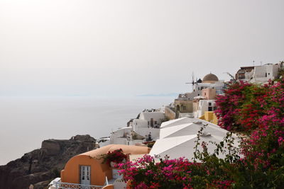 Scenic view of sea and buildings against clear sky