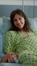 Portrait of a smiling young woman lying on bed at home