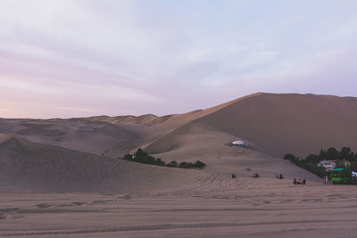 View of sand in desert with tourists