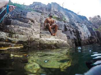 Full length of shirtless man on rock