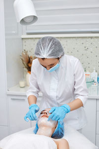 Side view of doctor examining patient in bathroom