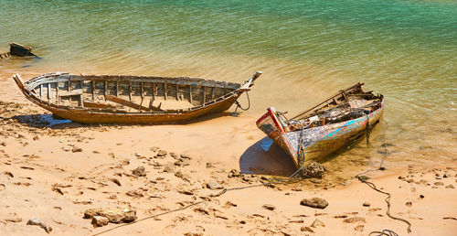 Abandoned boat moored on beach