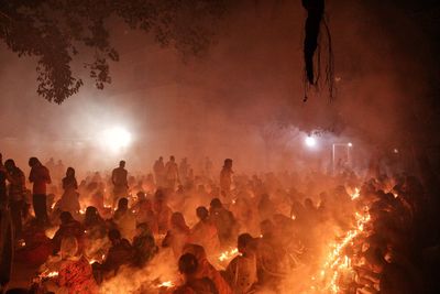 People are praying at rakher upobash under big tree in a smokey environment