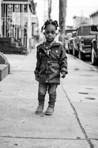 Full length portrait of boy standing on footpath