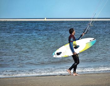 Full length of man with surfboard on beach