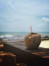 Close-up of bread on table at beach against sky