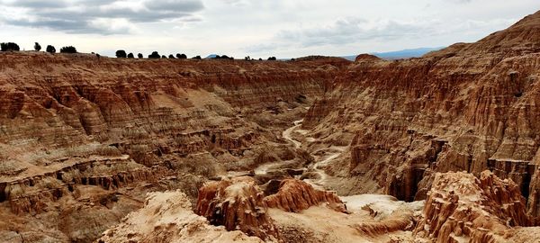 Panoramic view of rocks on landscape against cloudy sky